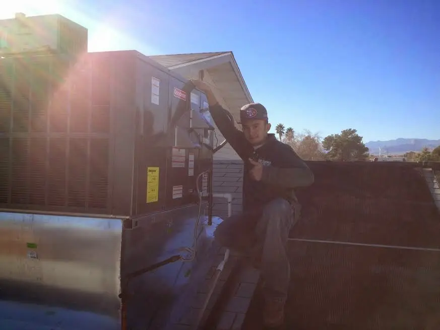 HVAC technician performing Boiler Repair on a rooftop unit in Reno